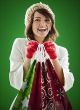 Mixed race woman holding Christmas shopping bags