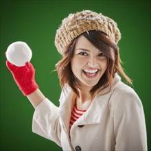 Mixed race woman throwing snowball