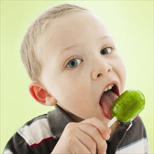 Caucasian boy licking lollipop