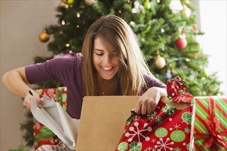 Caucasian woman opening Christmas gift