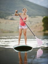 Caucasian woman on stand up paddle board