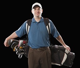 Caucasian golfer carrying golf bag