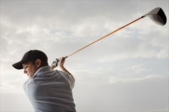 Caucasian golfer swinging golf club