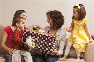 Caucasian family giving grandmother gift