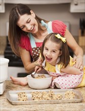 Caucasian mother and daughter baking cookies
