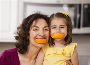 Caucasian grandmother and granddaughter eating fruit