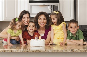 Caucasian family in kitchen with birthday cake