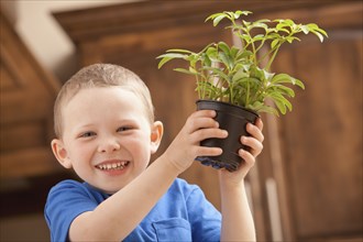Caucasian boy holding potted plant