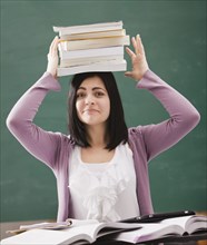Caucasian student balancing books on head