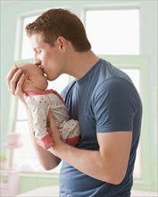 Caucasian father kissing baby girl