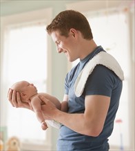 Caucasian father holding baby girl