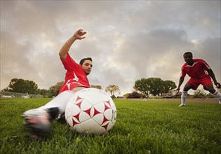 Hispanic soccer player kicking the ball