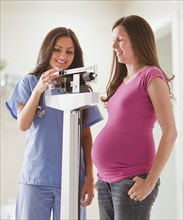 Nurse weighing pregnant woman