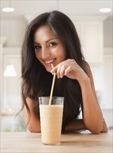 Mixed race woman drinking smoothie