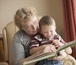 Caucasian grandmother reading book to grandson