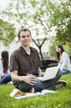 Caucasian man studying in grass