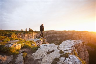 Caucasian man standing on remote cliff