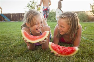 Caucasian girls eating watermelon