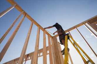 Caucasian man measuring frame on construction site