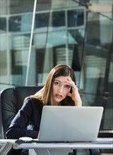 Stressed Caucasian businesswoman at laptop