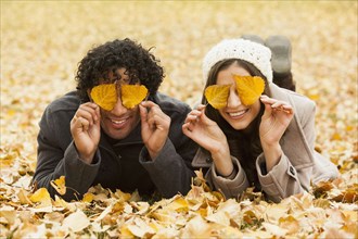 Couple playing in autumn leaves
