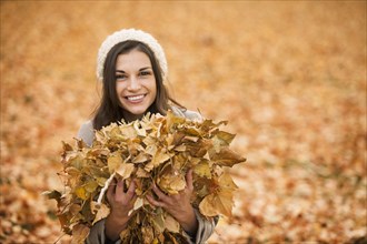 Caucasian woman playing in autumn leaves