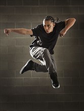 Hispanic dancer leaping in mid air