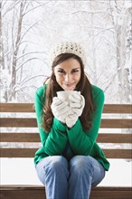 Caucasian woman having cup of coffee in snow