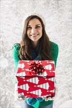 Caucasian woman holding Christmas gift in snow