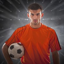 Hispanic soccer player holding ball