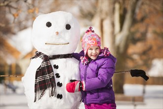 Caucasian girl building snowman in snow