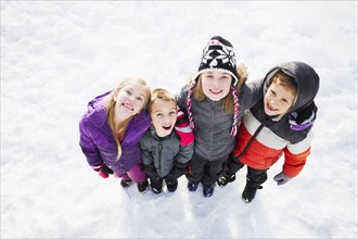 Caucasian children standing in snow outdoors