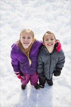 Caucasian children standing in snow outdoors