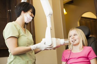 Technician making x-ray of girl's teeth