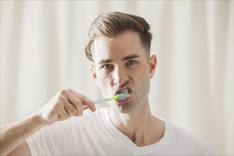 Caucasian man brushing his teeth