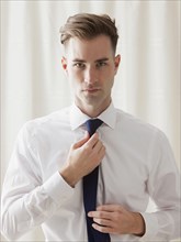 Caucasian businessman adjusting his tie