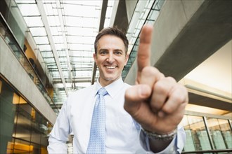 Caucasian businessman holding up finger