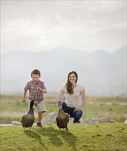 Caucasian mother and son feeding ducks