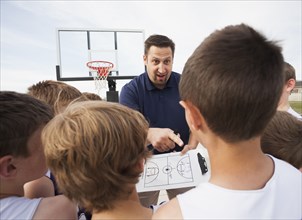 Caucasian coach talking to basketball team