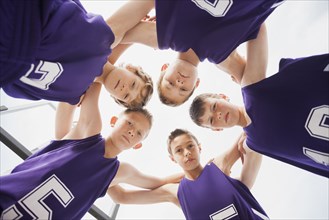 Caucasian basketball team in huddle