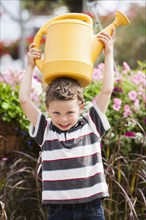 Caucasian boy playing with watering can