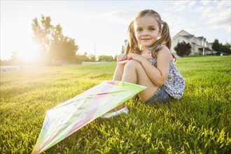 Caucasian girl with kite in grass