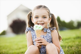 Caucasian girl eating ice cream outdoors