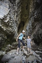 Caucasian mother and son exploring cave