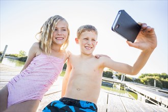 Caucasian children taking selfie with cell phone