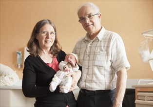 Senior Caucasian couple holding newborn grandson