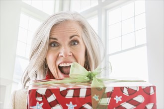 Portrait of enthusiastic Caucasian woman with Christmas gift