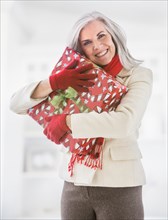Portrait of Caucasian woman hugging Christmas gift