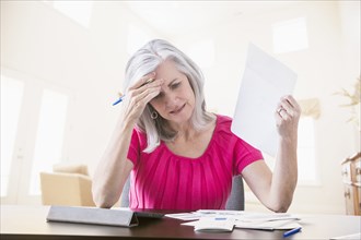 Frustrated Caucasian woman paying bills online