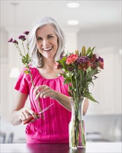 Portrait of smiling Caucasian woman arranging flowers